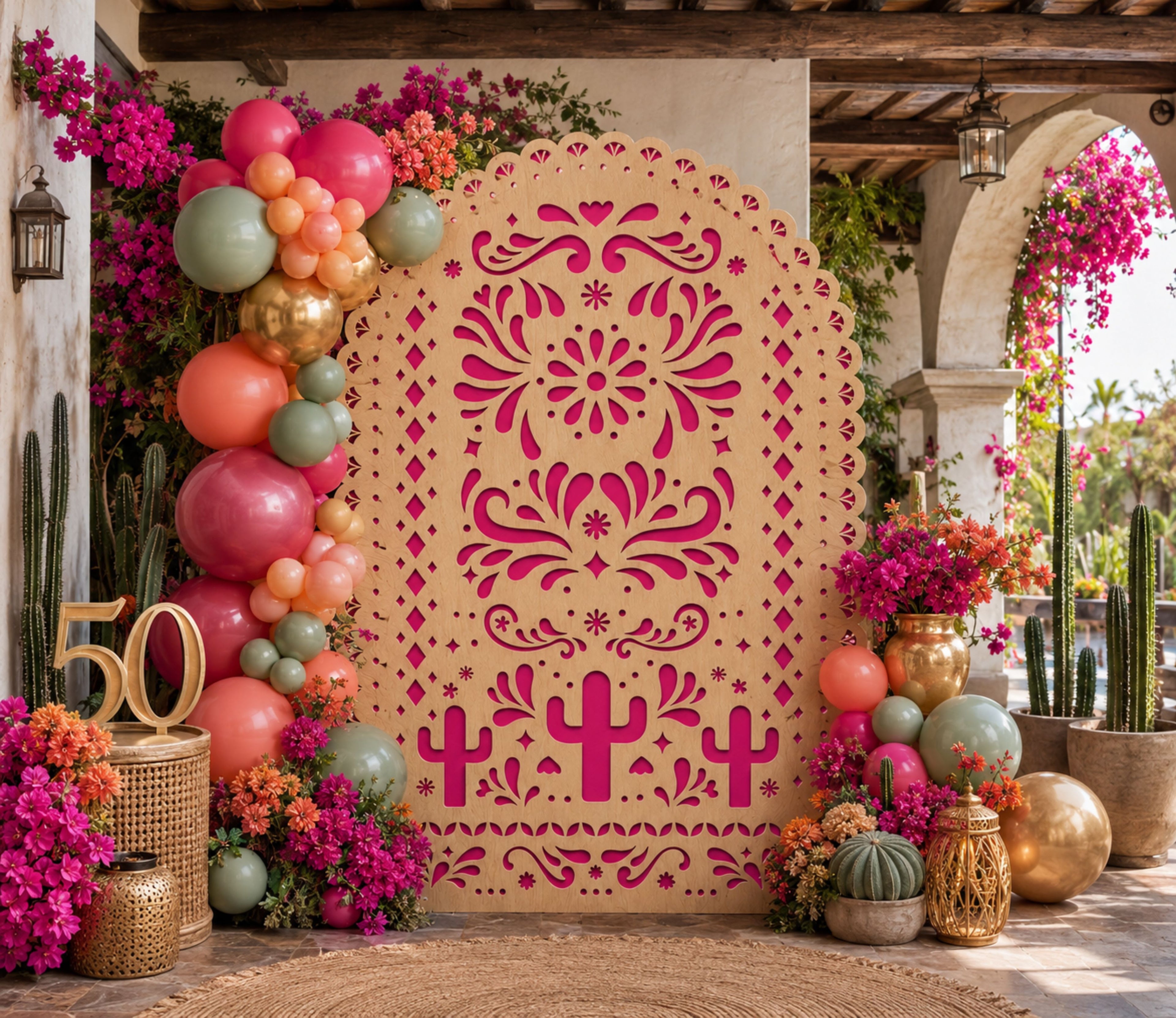 Pink and orange papel picado backdrop set with colorful flowers and balloons for Mexican celebration