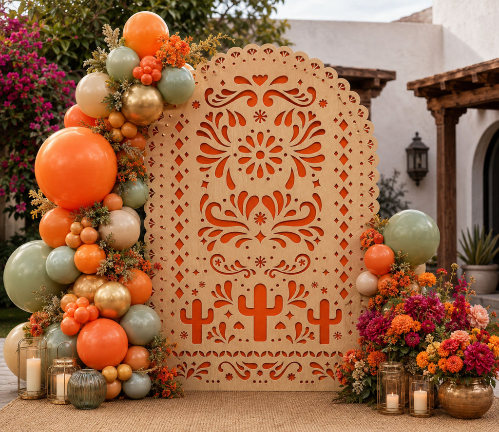 Terracotta papel picado backdrop with orange and green balloon garland for fiesta party decor