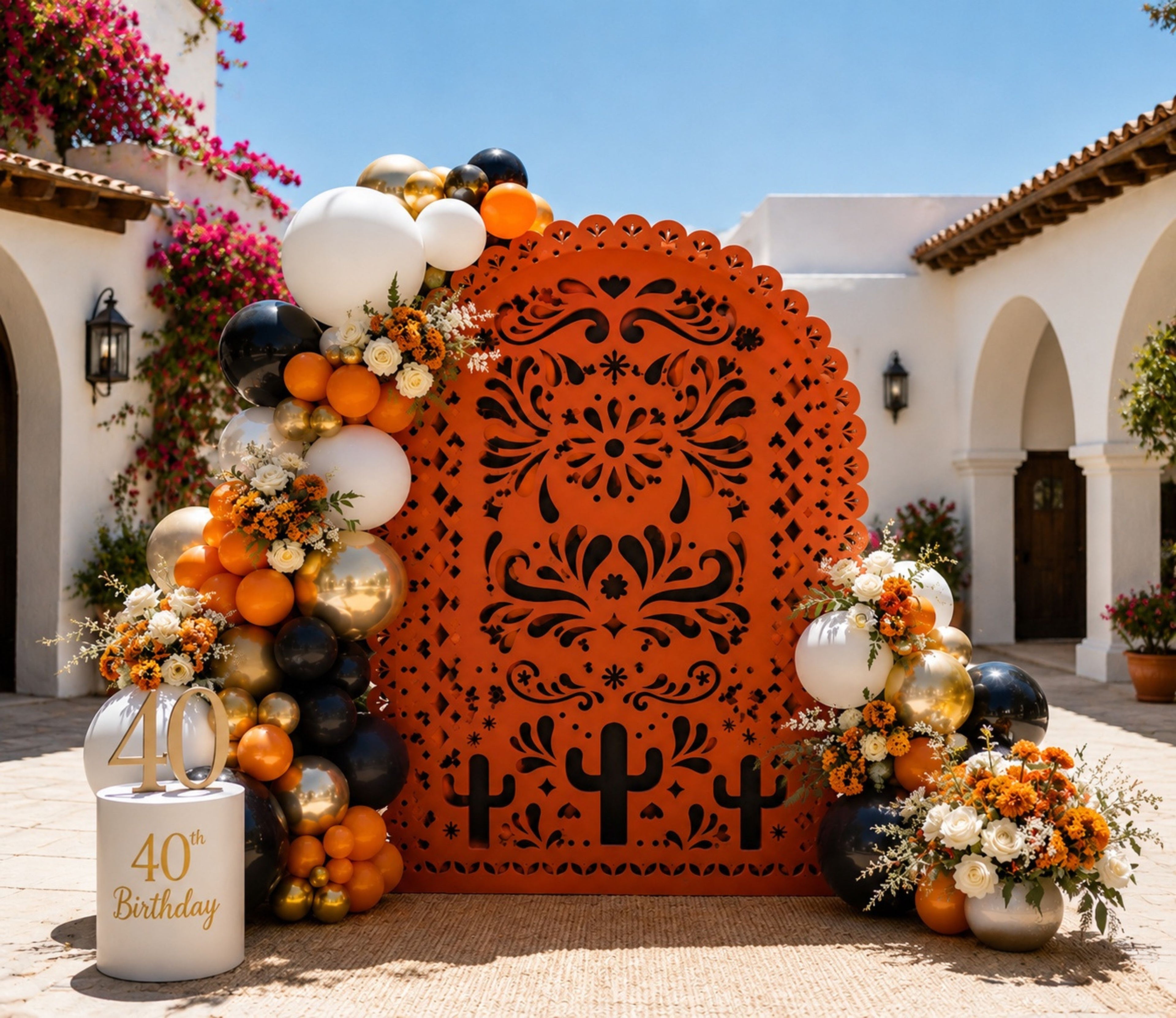 Terracotta papel picado backdrop with orange, black, white and gold balloons for Mexican-inspired birthday decor