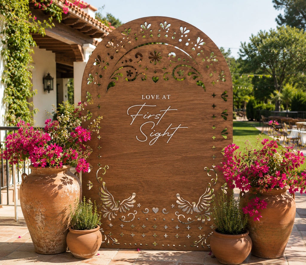Personalized natural wood papel picado wedding backdrop with floral details for Mexican inspired outdoor wedding decor