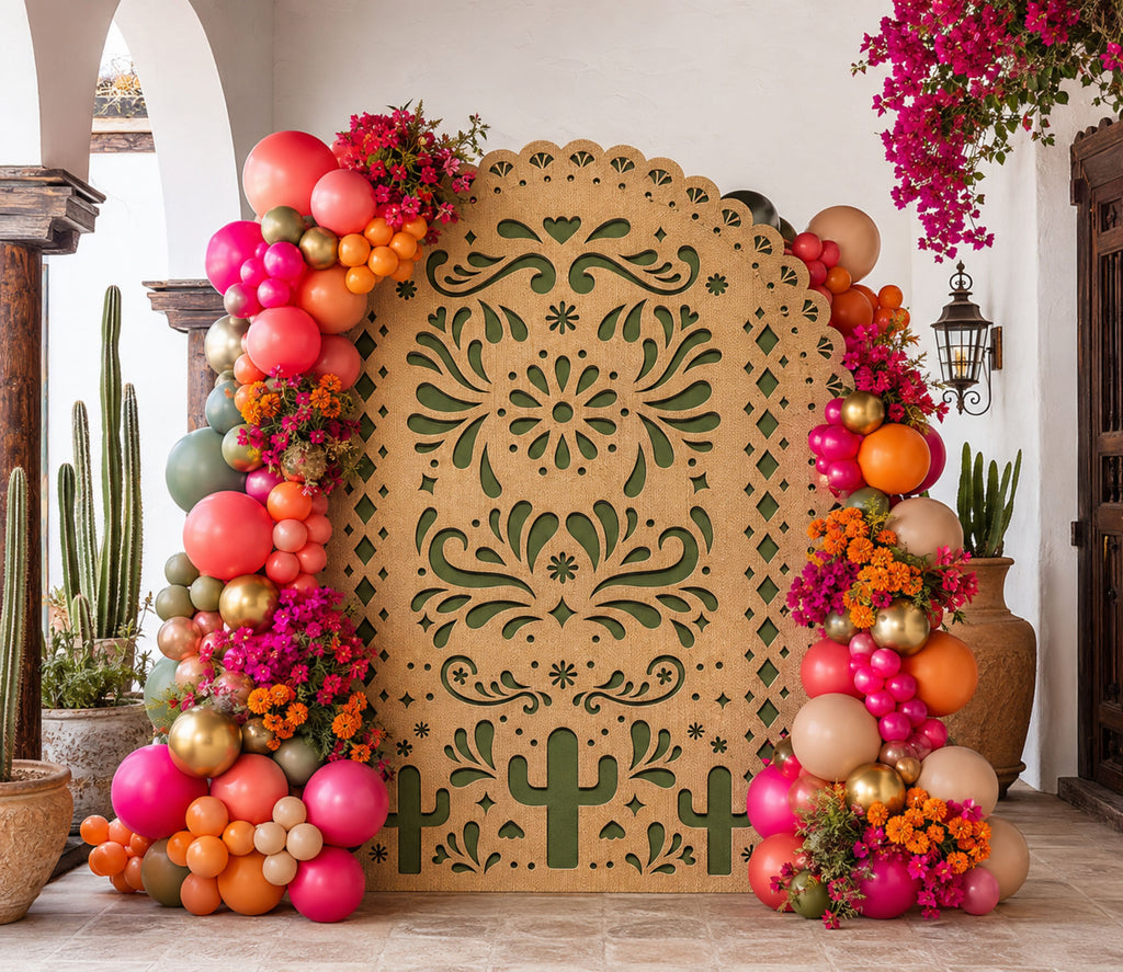 Green printed papel picado backdrop with colorful balloon garland for Mexican fiesta celebration